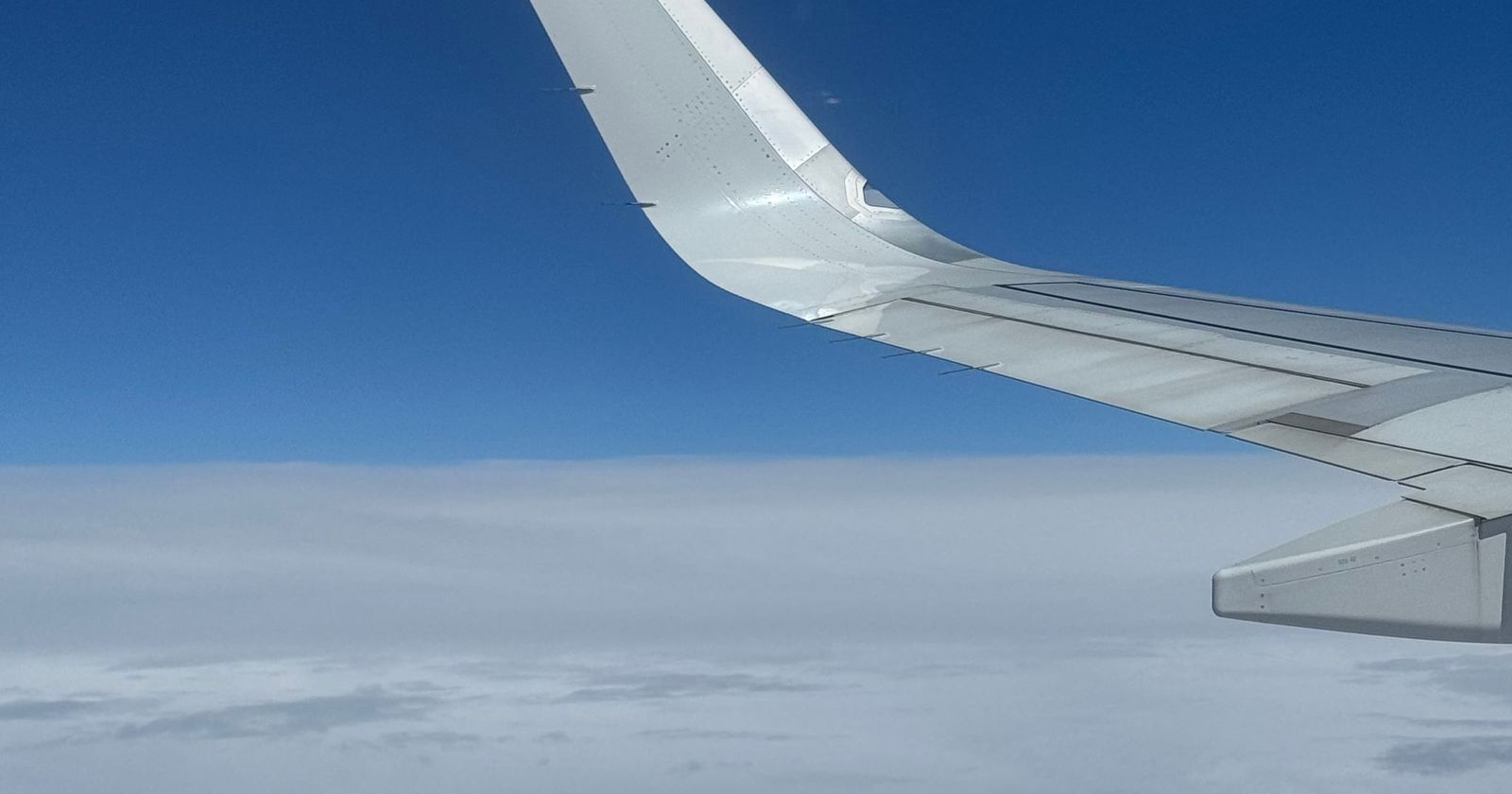 An aeroplane wing above the clouds